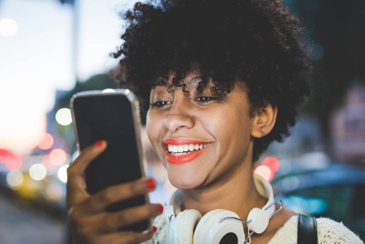 femme souriant devant son smartphone