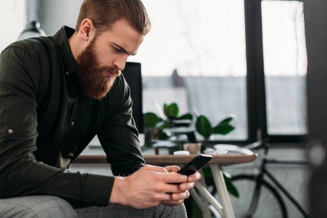 homme qui regarde son smartphone